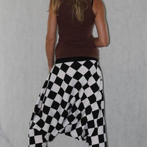 May include: Black and white checkered harem pants with a brown tank top.