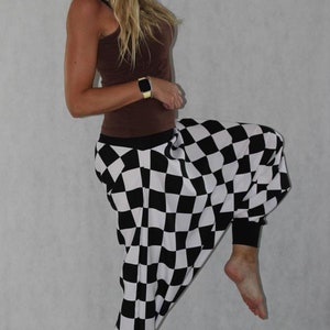 May include: Black and white checkered pants with a loose, wide-leg fit. The pants are made of a soft, comfortable fabric and have a relaxed, casual style.
