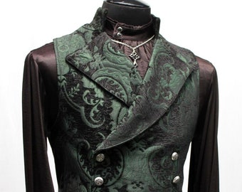 May include: A dark green patterned waistcoat with a shawl collar and silver buttons. The waistcoat is worn over a black shirt with a ruffled collar.