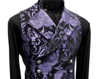 May include: A double-breasted waistcoat featuring a purple and black floral damask pattern with a high collar and silver-toned buttons. The garment is worn over a solid black long-sleeved shirt, showcasing a structured fit and a wide lapel design.