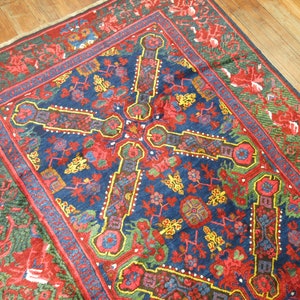 May include: A vintage Persian rug with a deep blue background and intricate floral patterns in shades of red, yellow, and green. The rug has a central medallion and a border with a repeating design.