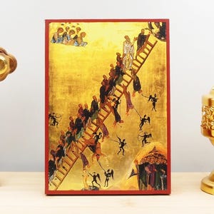 Könnte beinhalten: Religiöse Ikone, die eine goldene Leiter mit auf- und absteigenden Figuren darstellt. Das Kunstwerk hat einen roten Rahmen und einen goldenen Hintergrund. Das Bild zeigt Engel und Dämonen.