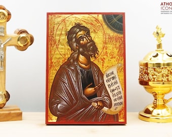 May include: A hand-painted icon of Saint John the Baptist on a wooden panel. The icon is painted in a traditional Byzantine style with gold leaf accents. The saint is depicted holding a scroll with the text "ΑΚΟΕ ΟΥΡΑΝΕ ΒΗΘΗ ΕΚΕΙΝΟΙΣ ΟΙ ΚΥΡ ΟΣ ΕΘΑ ΑΓΙΟΝ".