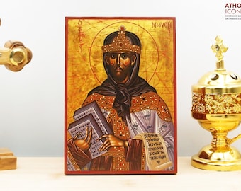 May include: Hand-painted icon of Saint Sophia, a Byzantine empress, holding a book. The icon is on a wooden panel with a red border and gold background. The icon is labelled "Sophia" in Greek.