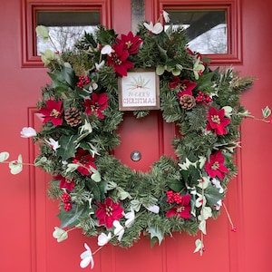 Winter wreath for front door, poinsettia flowers and berries, wooden Merry Christmas decor