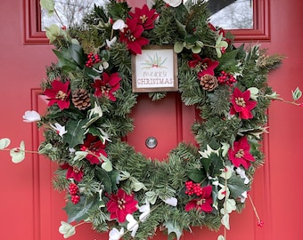 Winter wreath for front door, poinsettia flowers and berries, wooden Merry Christmas decor