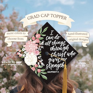 Puede incluir: Un adorno negro para gorra de graduación con un diseño floral en rosa y blanco, y el texto "Todo lo puedo en Cristo que me fortalece." Incluye una borla dorada. El adorno está ilustrado a mano.