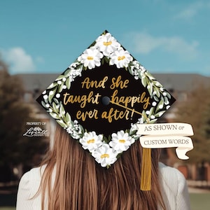 A person with long brown hair wearing a graduation cap with a floral design and text on it.