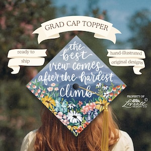 Puede incluir: Un adorno floral para gorro de graduación con la frase "the best view comes after the hardest climb". La gorra está decorada con flores coloridas y una borla dorada. También se ven las palabras "ready to ship" y "hand-illustrated original designs".