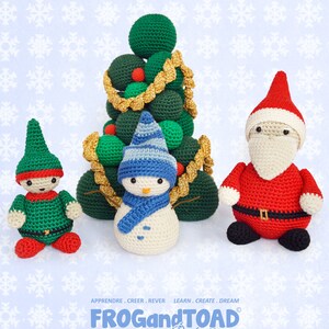 Pode incluir: Uma coleção de decorações de Natal de crochê feitas à mão. O conjunto inclui uma árvore de Natal verde, um boneco de neve com chapéu e cachecol azuis, um elfo em verde e vermelho e uma figura do Papai Noel em vermelho e branco.