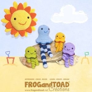 May include: A collection of crocheted sea creatures and a smiling sun. The jellyfish are in blue, yellow, green, and purple. The sun is yellow and orange. The image includes the text "FROG and TOAD Creations".
