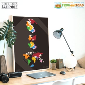May include: A framed print featuring a pixelated world map in vibrant colors against a dark background. The print includes the text "EDITIONS TADPOLE" and "FROG and TOAD Creations". The artwork is displayed on a wooden desk with a laptop, lamp, and decorative items.