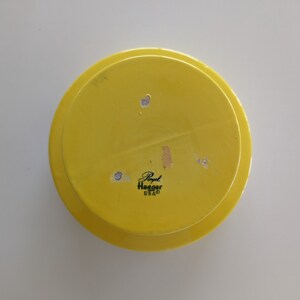 May include: Yellow ceramic plate with a black label that reads "Royal Haeger USA".