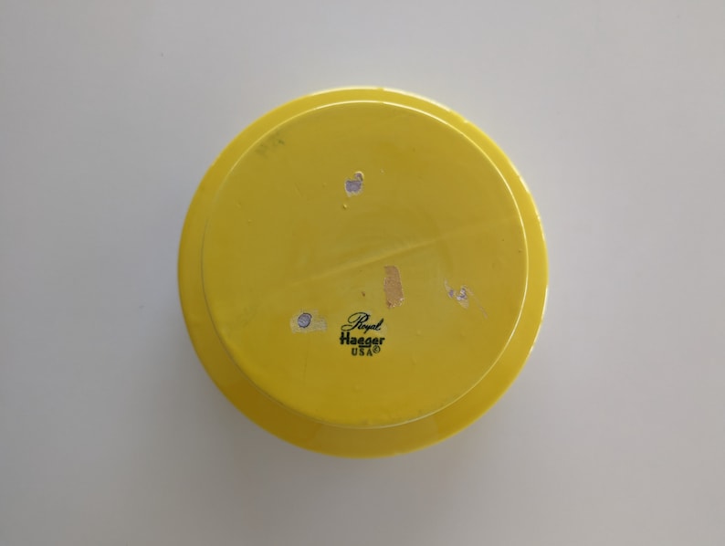 May include: Yellow ceramic plate with a black label that reads "Royal Haeger USA".