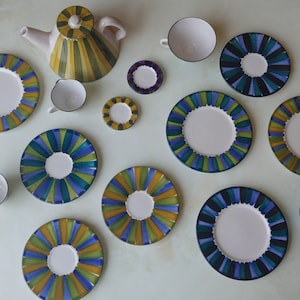 May include: A set of vintage teacups and saucers with a blue, green, and yellow geometric pattern. The set includes a teapot with a matching design.