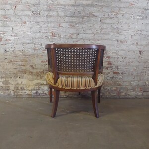 May include: A brown wooden chair with a woven cane back and a striped fabric seat.