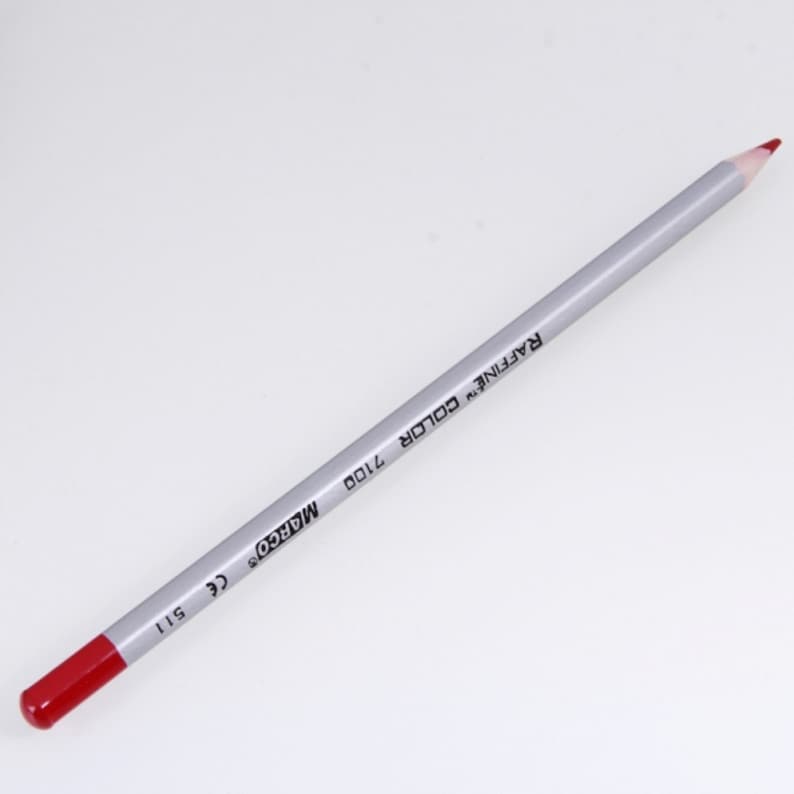 May include: A red colored pencil with a silver barrel. The barrel is labeled "MARCO'S" and "RAFFINE COLOR 2100".
