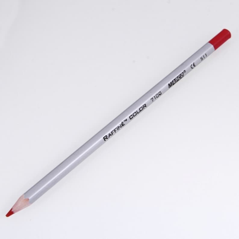 May include: A red colored pencil with a silver barrel. The barrel is labeled "RAFFINE&trade; COLOR 7100 MARCO&reg; CE 511".