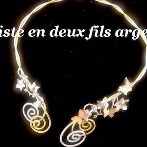 Peut inclure: Un collier en argent et or avec un design délicat représentant des papillons et des feuilles de lierre. Le collier est composé de deux fils de métal et a un aspect simple et élégant.