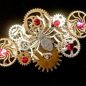 Horquilla de araña steampunk con engranajes y cristales Swarovski rojos
