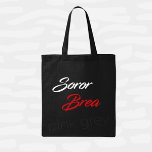 May include: Black tote bag with white text that says "Soror Brea" and pink and grey text that says "pink grey"