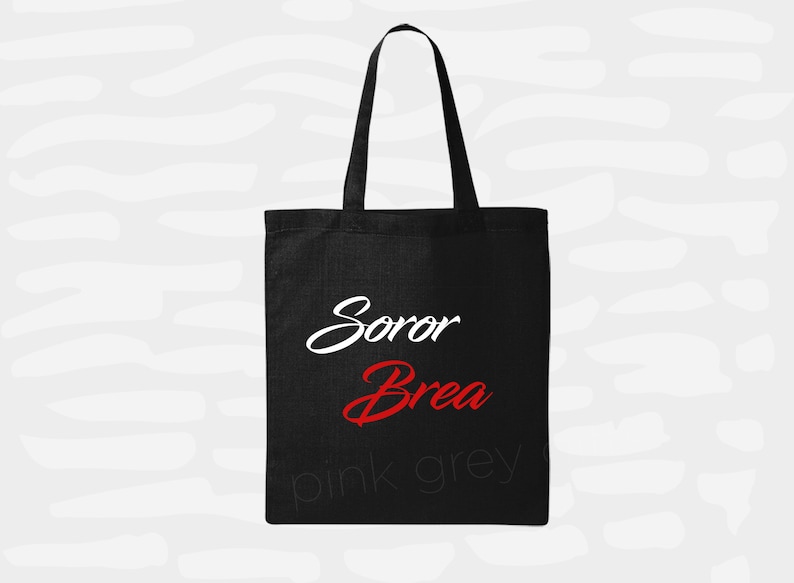 May include: Black tote bag with white text that says "Soror Brea" and pink and grey text that says "pink grey"