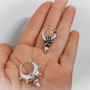 Peut inclure: Une paire de boucles d'oreilles cr&eacute;oles en argent avec un motif de croissant de lune et une forme de larme pendante.