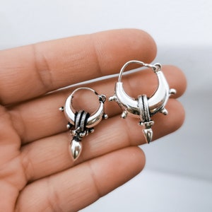 Peut inclure: Deux boucles d'oreilles cr&eacute;oles en argent avec un design pointu. Les boucles d'oreilles ont une surface textur&eacute;e et une petite perle ronde au bas.