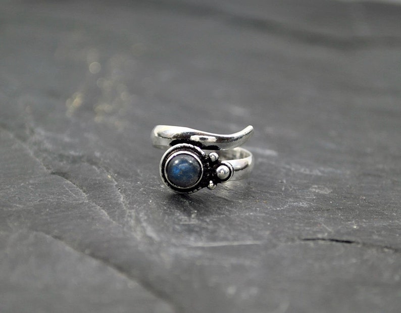 Op de afbeelding: Zilveren ring met een blauwe labradorite edelsteen gezet in een swirl-ontwerp.