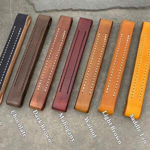 Puede incluir: Ocho tiradores de caj&oacute;n de cuero en diferentes colores: negro, chocolate, marr&oacute;n oscuro, caoba, nogal, marr&oacute;n claro, marr&oacute;n silla de montar. Cada tirador tiene dos filas de costuras blancas.