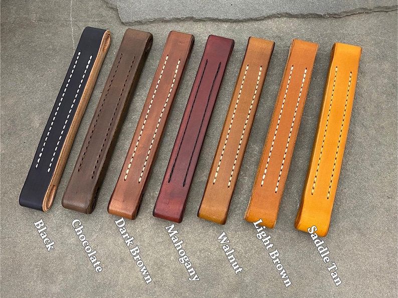 Puede incluir: Ocho tiradores de caj&oacute;n de cuero en diferentes colores: negro, chocolate, marr&oacute;n oscuro, caoba, nogal, marr&oacute;n claro, marr&oacute;n silla de montar. Cada tirador tiene dos filas de costuras blancas.
