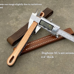 Puede incluir: Primer plano de una correa de perro de cuero que se mide con un calibre. El calibre lee 0,5930 pulgadas. El texto "Dogbone XL's are around 0.6" thick" es visible debajo de la correa.