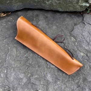 以下が含まれることがあります： 白いステッチとタッセル付きの茶色の革製の矢筒