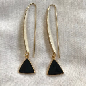 Long gold earrings with black enamel triangle pendant