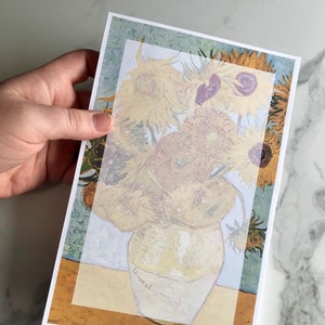 Könnte beinhalten: Ein Gemälde einer Vase mit Sonnenblumen von Vincent van Gogh. Die Sonnenblumen sind gelb und braun, und die Vase ist weiß. Der Hintergrund ist hellblau.