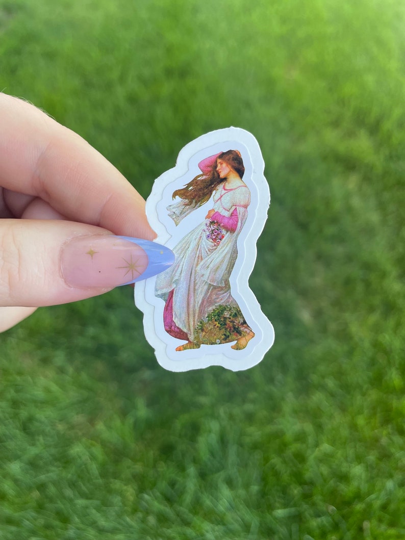 May include: A sticker featuring a vintage illustration of a woman in a flowing white dress with pink accents, holding a bouquet of flowers. The sticker has a white border and is on a green background.