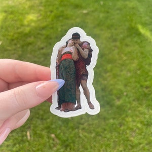 Puede incluir: Una pegatina con una pintura vintage de una pareja abrazándose. La mujer lleva un vestido verde con una faja roja y el hombre lleva una túnica marrón. La pegatina está impresa en papel blanco.