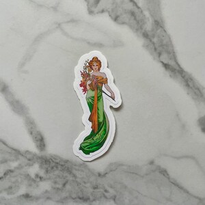 May include: A sticker featuring a woman in a green and gold dress holding a bouquet of flowers. The woman is standing on a white background.