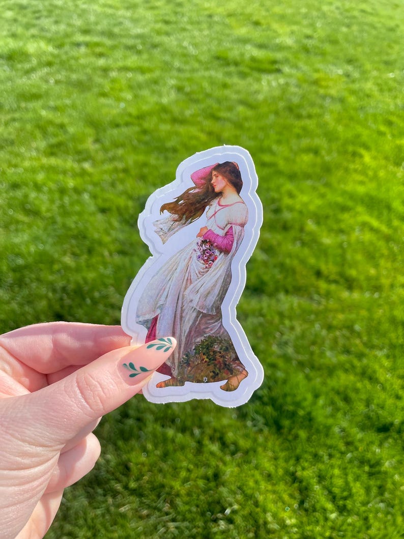 May include: A sticker featuring a painting of a woman in a white dress with pink accents, holding a bouquet of flowers. The woman is standing in a field of flowers.