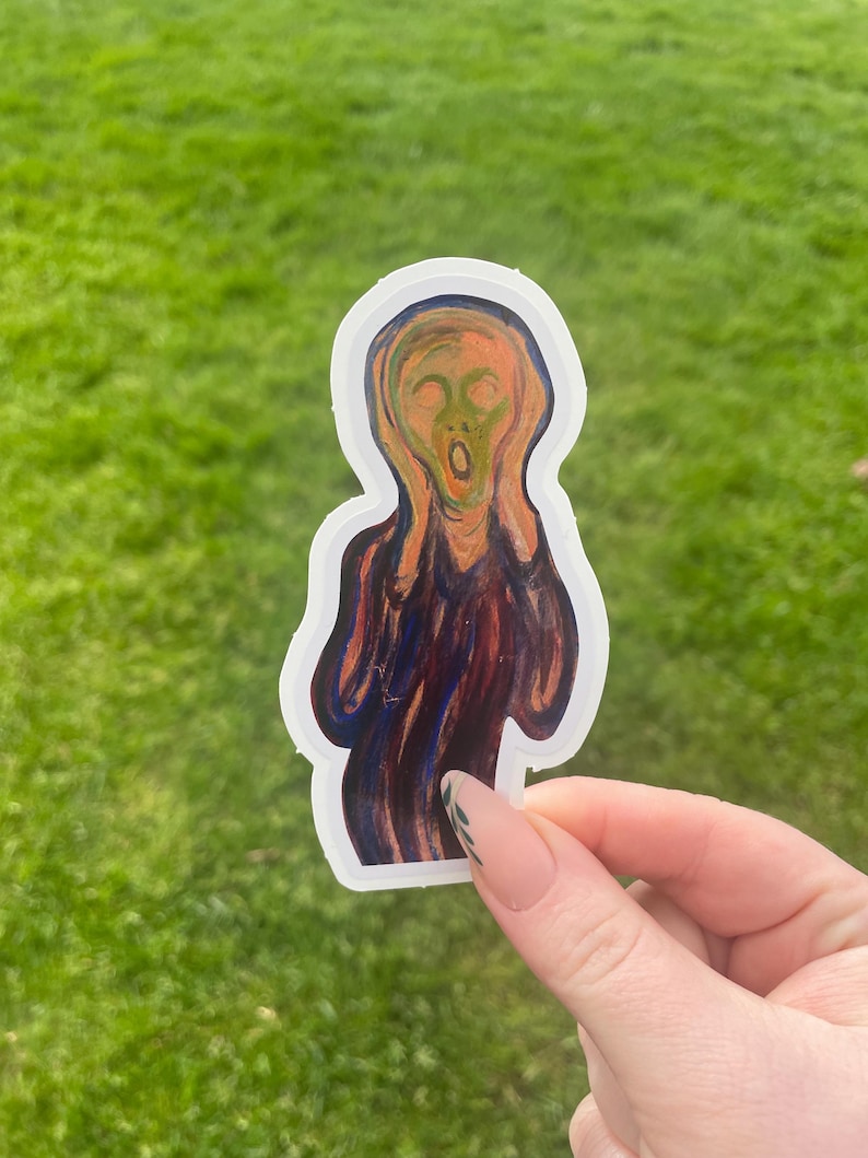 Puede incluir: Una pegatina con la ic&oacute;nica obra de arte de Edvard Munch, "El Grito". La pegatina representa una figura con la boca muy abierta y las manos en la cara, en tonos naranja, rojo y azul. La pegatina tiene un borde blanco y se sostiene sobre un fondo de hierba verde.