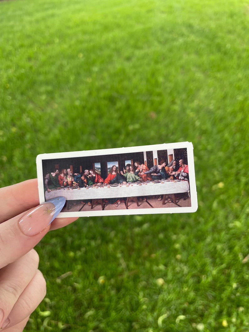 May include: A sticker featuring a reproduction of Leonardo da Vinci's painting "The Last Supper". The sticker shows Jesus and his disciples gathered around a table.