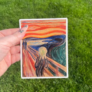 May include: A sticker featuring a painting of a person screaming with a bright red, orange, and yellow sky in the background. The painting is known as "The Scream" by Edvard Munch.