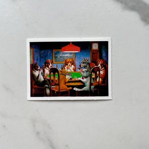 May include: A vintage illustration of a group of dogs playing cards around a green felt table. The dogs are wearing collars and are sitting on chairs. There is a red lamp hanging above the table. The illustration is in a white frame.