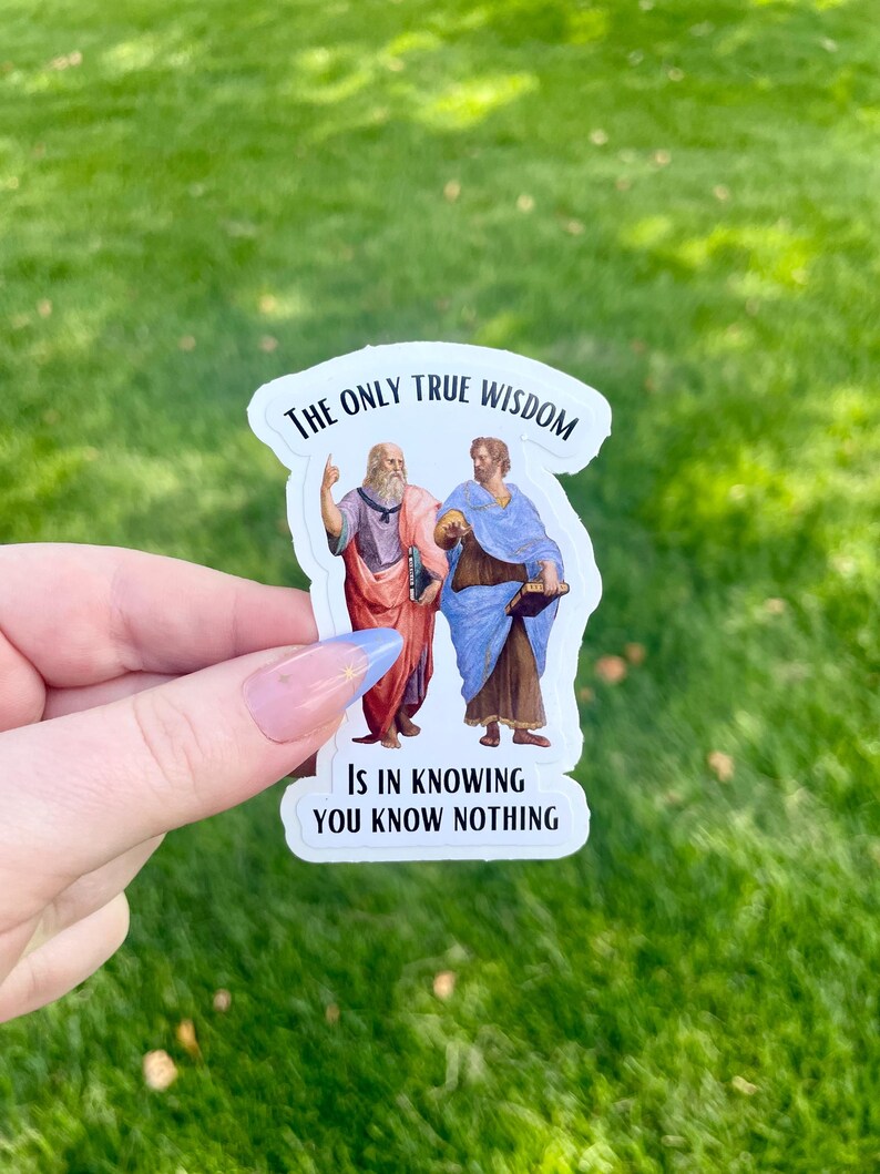 May include: White sticker with a quote from Socrates and Plato. The quote reads "The only true wisdom is in knowing you know nothing". The sticker features illustrations of Socrates and Plato.