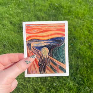 May include: A sticker featuring a reproduction of Edvard Munch's famous painting "The Scream". The painting depicts a figure with a distorted face and a swirling, colourful background.