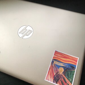 May include: A silver laptop with the HP logo and a sticker of Edvard Munch's "The Scream" painting.