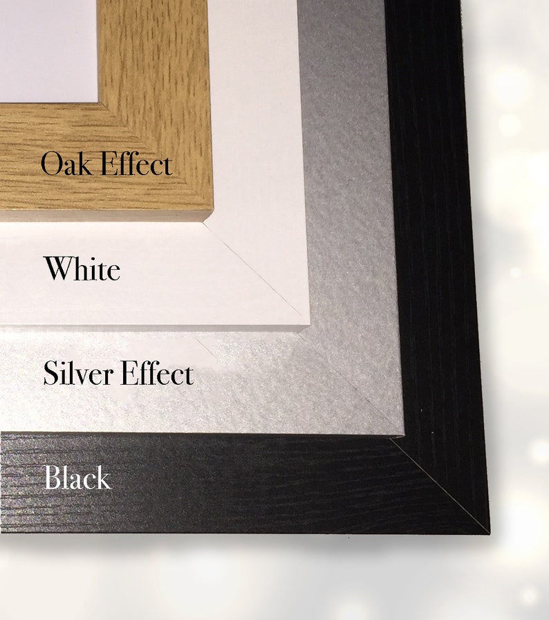 May include: A layered display of picture frame samples. The top frame is oak effect, followed by white, silver effect, and black frames. Each frame is labeled with its color or finish.