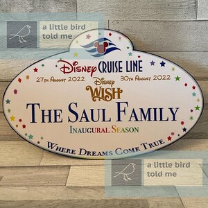 Puede incluir: Una etiqueta de nombre ovalada blanca de Disney Cruise Line con ribete azul. La etiqueta presenta una cabeza de Mickey Mouse con un volante de barco azul y una ola azul. El texto en la etiqueta dice "Disney Cruise Line", "27 de agosto de 2022", "Disney Wish", "30 de agosto de 2022", "The Saul Family", "Inaugural Season", y "Where Dreams Come True".