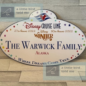 Puede incluir: Una etiqueta de nombre ovalada blanca de Disney Cruise Line con estrellas de colores y un logotipo de cabeza de Mickey Mouse. La etiqueta dice "Disney Cruise Line", "27 de agosto de 2022", "Disney Wonder", "30 de agosto de 2022", "The Warwick Family", "Alaska" y "Where Dreams Come True".