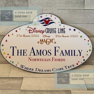 Puede incluir: Una etiqueta de nombre ovalada blanca de Disney Cruise Line con un borde azul y estrellas de colores. La etiqueta dice "Disney Cruise Line", "27 de agosto de 2022", "Disney Magic", "30 de agosto de 2022", "The Amos Family", "Norwegian Fjords" y "Where Dreams Come True".